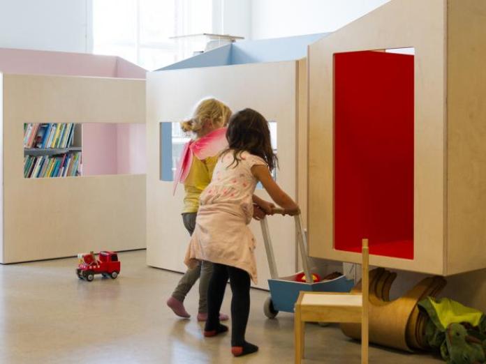 To piger leger i de store huse i lokalet